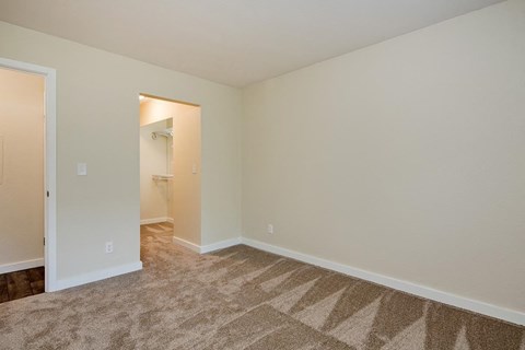 a living room with carpet and a door to a bathroom